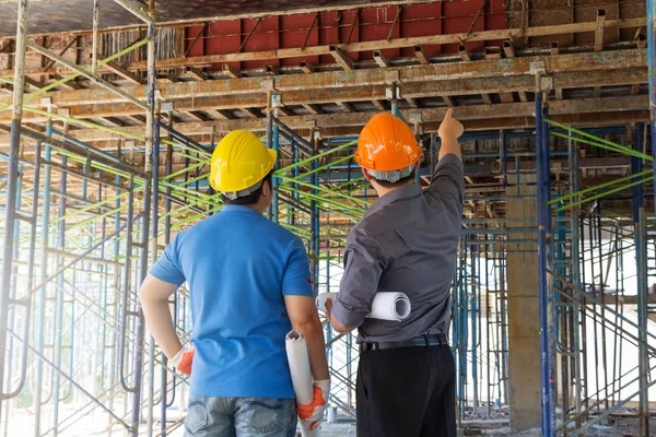 Conceptos de construcción, Ingeniero y Arquitecto trabajando en el sitio de construcción con planos — Foto de Stock