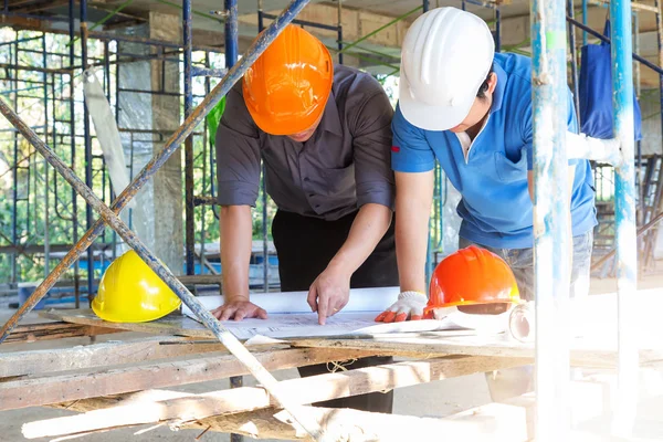 Conceptos de construcción, Ingeniero y Arquitecto trabajando en el sitio de construcción con planos — Foto de Stock