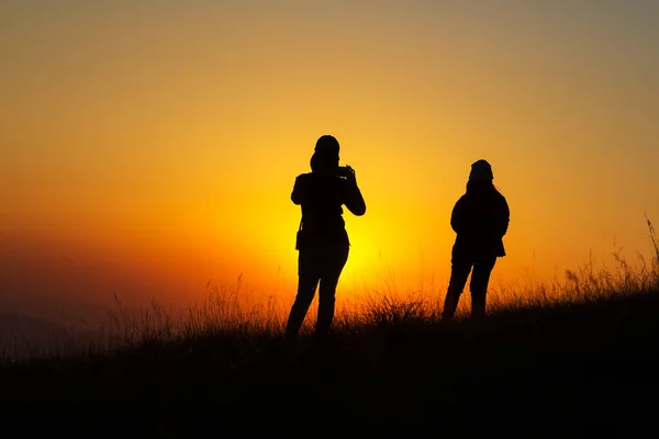 Silhouette von Menschen, die Spaß bei Sonnenuntergang haben — Stockfoto