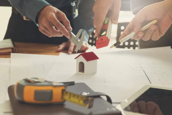 Ingenjör och arkitekt koncept, ingenjör arkitekter office team arbeta och diskutera med ritningar och husmodell, Vintage effekt — Stockfoto