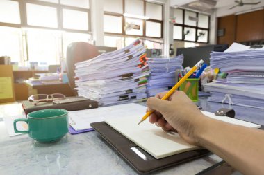İş ve Finans kavramı ofis çalışma, işadamı bir defter tamamlanmamış belgeler arka plan yığını ile yazma