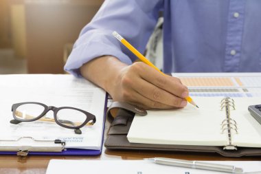 İş ve Finans kavramı ofis çalışma, işadamı bir defter tamamlanmamış belgeler arka plan yığını ile yazma