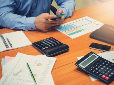 İş ve Finans office çalışma, hesaplamak için akıllı telefon kullanma ve analiz grafik tartışırken işadamı kavramı