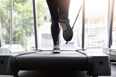 Spor salonunda, yağ yakıcı kardiyo egzersiz makine koşma üstünde çalışan fitness kadın