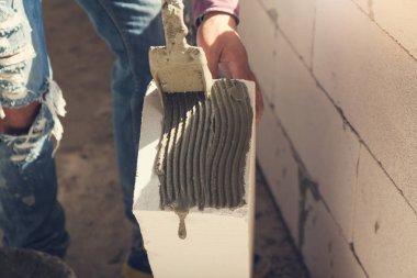 İnşaat kavramı, çimento işçi wite blok yükleme inşaat sahasında duvar kurmak için