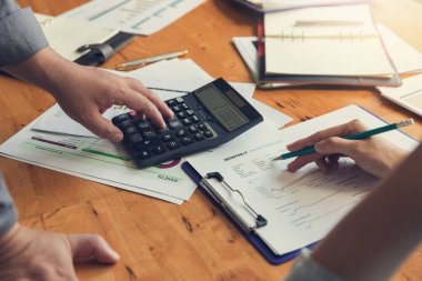 İş ve Finans office çalışma, analiz grafik tartışmak için hesap makinesini kullanarak işadamları ekip çalışması kavramı