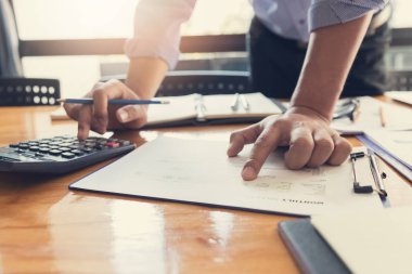 İş ve Finans office çalışma, analiz grafik tartışmak için hesap makinesini kullanarak işadamları ekip çalışması kavramı