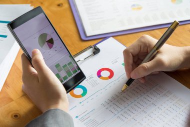 İş ve Finans office çalışma, akıllı telefon kullanarak ve satış analizi grafiği tartışırken işadamı kavramı