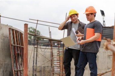 İnşaat mühendisi ve mimar inşaat alanında mavi baskı ile çalışma kavramı