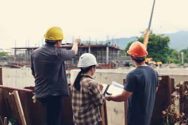 İnşaat mühendisi ve mimar inşaat alanında mavi baskı ile çalışma kavramı