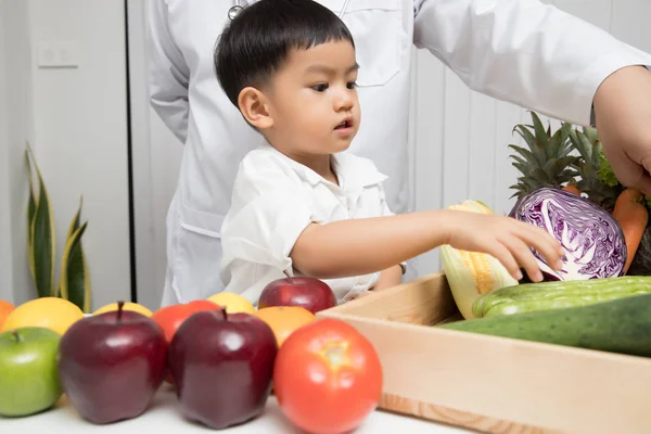 Healthy and nutrition concept. Kid learning about nutrition with doctor to choose eating fresh fruits and vegetables.