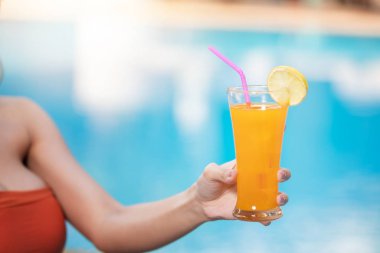 Kokteyl ile havuzda dinlendirici bikinili güzel kadın.