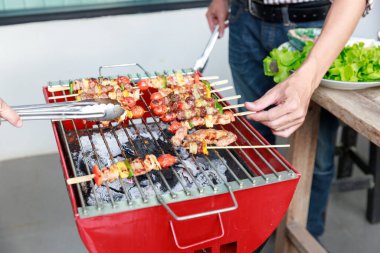 Friends having party and cooking barbecue in gardern.
