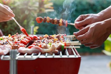 Friends having party and cooking barbecue in gardern.