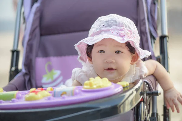 Retrato de dulce niña asiática sentada en cochecito —  Fotos de Stock