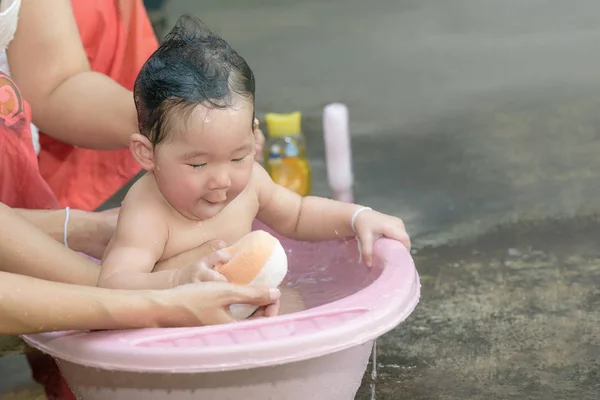 Девочка играет в губку во время купания . — стоковое фото