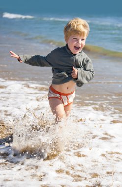 Deniz plajda çalışan mutlu çocuk 