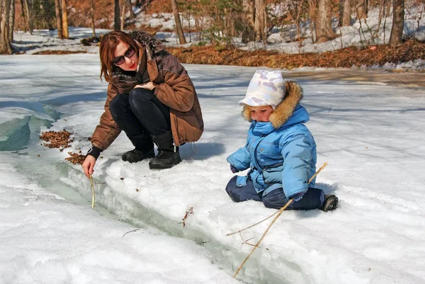 Familie von Mutter mit Kind spielt im Schnee Frühlingswald stre — Stockfoto