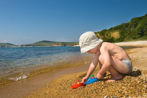 Kid playing with colorful toys on the beach Stock Image