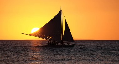 Boracay Adası daki Filippi kenti yakınlarında gün batımında denizde yelkenli tekne