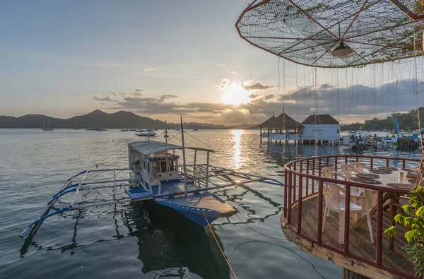 Traditional boat at terrace cafe at Coron Town at sunset view — Stock Photo, Image
