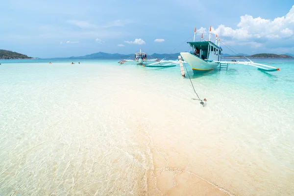 Spiaggia di sabbia tropicale con turisti e barche sul Bulog Dos Foto Stock Royalty Free