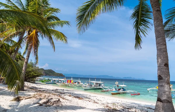 Spiaggia tropicale con barche sull'isola di Malcapuya, Busuanga Foto Stock Royalty Free