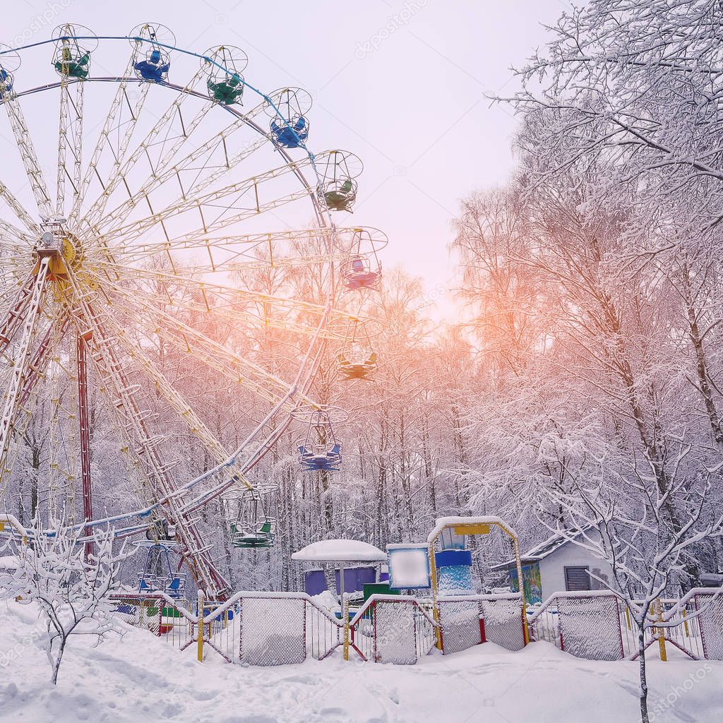 Snow covered Ferris wheel  surrounded by snowcovered trees