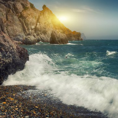 Kayalık deniz kıyısı ve güneşli bir dalgalar