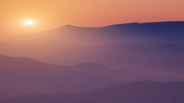 Siluetas de las colinas de montaña al atardecer — Foto de Stock