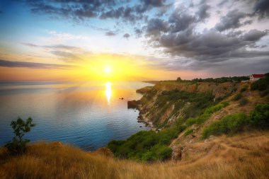Cape Fiolent dramatik günbatımında bush ve foregroun çim ile