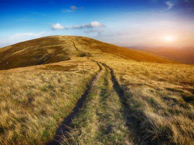 çayırlar batımında dağ aralığının üzerinden dolambaçlı yol