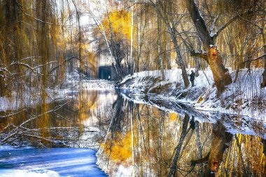 Gün batımında nehir kıyısında kış manzarası