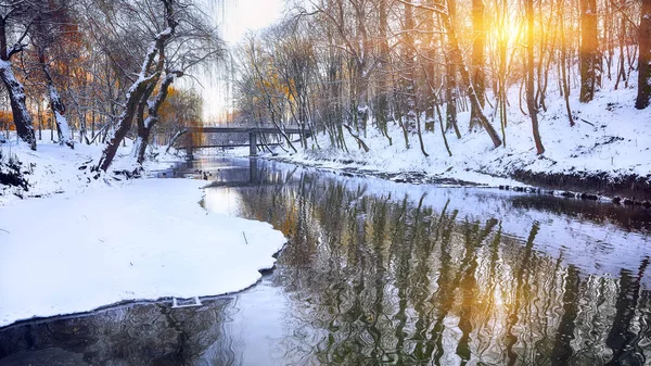 Paesaggio invernale lungo un fiume al tramonto — Foto Stock