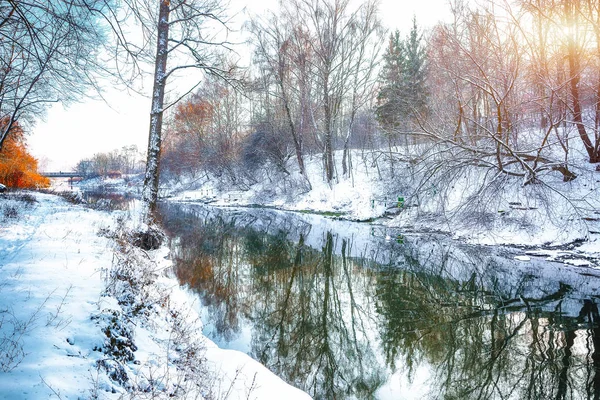 Paisagem de inverno por um rio ao pôr do sol — Fotografia de Stock