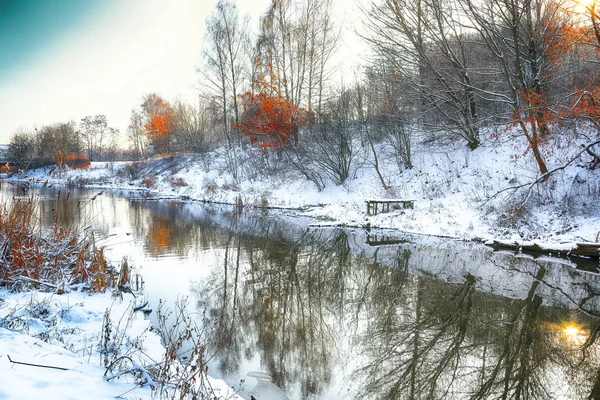 Paisaje invernal junto a un río al atardecer — Foto de Stock