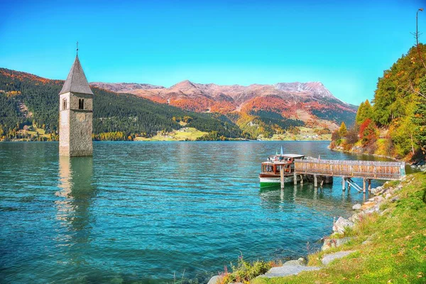 Fantástico paisaje del lago de otoño con un barco cerca del muelle y s — Foto de Stock