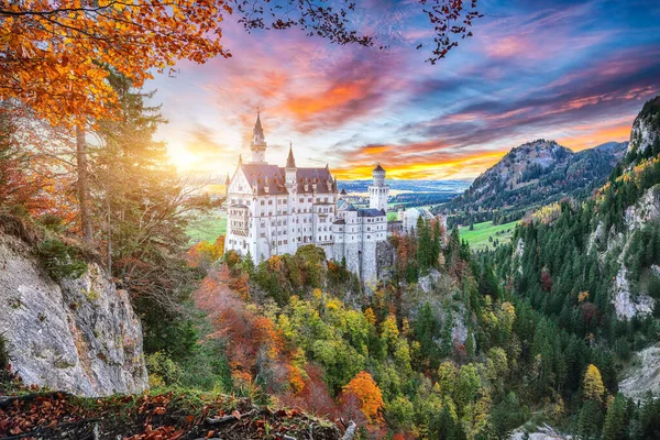 Sonbaharda ünlü Neuschwanstein Kalesi 'nin görkemli günbatımı manzarası.