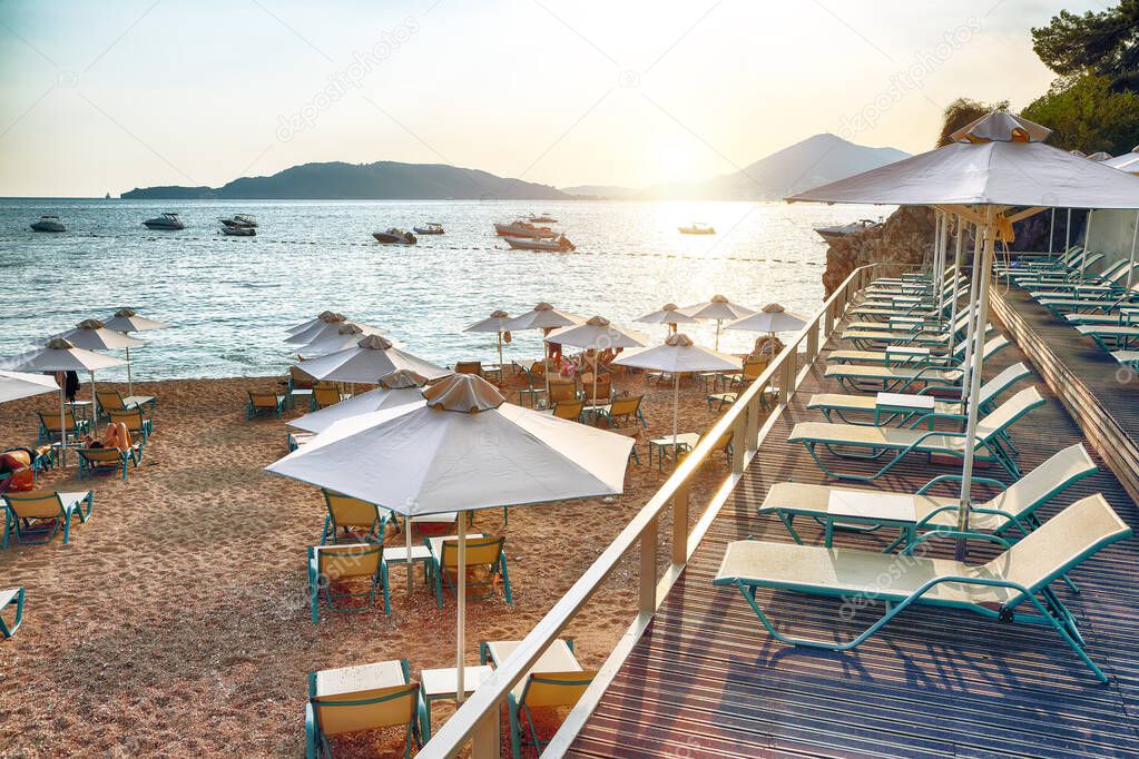 Picturesque summer view of Adriatic sea coast in Budva Riviera near Przno village. Cozy beach with umbrellas. Location: Przno village, Montenegro, Balkans, Europe