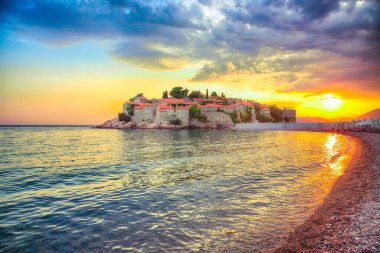 Budva yakınlarındaki lüks sahil ve adacık Sveti Stefan 'ın muhteşem günbatımı manzarası. Konum: Budva Riviera, Karadağ, Balkanlar, Adriyatik denizi, Avrupa