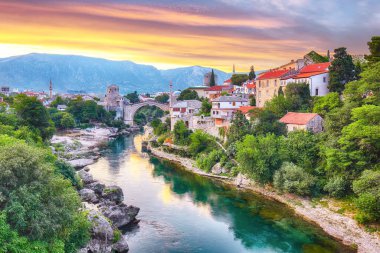 Mostar Köprüsü, evler ve minarelerle gün batımında Mostar 'ın muhteşem Skyline' ı. Konum: Mostar, Old Town, Bosna-Hersek, Avrupa