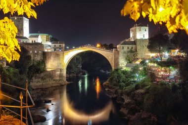 Akşamları Mostar Köprüsü, evler ve minarelerle Mostar 'ın görkemli akşam manzarası. Konum: Mostar, Old Town, Bosna-Hersek, Avrupa