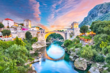 Akşamları Mostar Köprüsü, evler ve minarelerle Mostar 'ın görkemli akşam manzarası. Konum: Mostar, Old Town, Bosna-Hersek, Avrupa