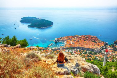 Mutlu kız, Dubrovnik 'teki eski şehir (ortaçağ Ragusa) ve Adriyatik Denizi' nin Dalmaçya kıyıları manzarasının keyfini çıkarıyor. Konum: Dubrovnik, Dalmaçya, Hırvatistan, Avrupa