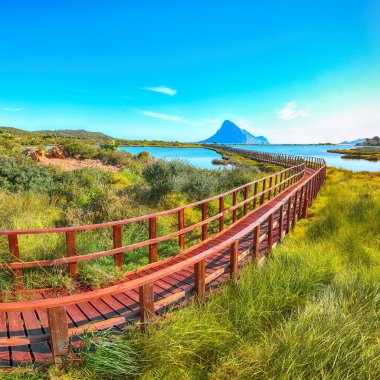 Porto Taverna plajına giden yaya geçidinden gün doğuyor.
