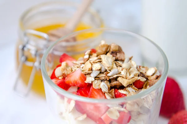 Healthy breakfast of homemade granola cereal with strawberry, nuts and fruit, honey with drizzlier background. Morning food, Diet, Detox, Clean Eating, Vegetarian concept. — Stock Photo, Image