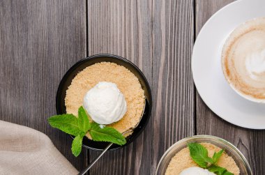 Üstten Görünüm elma kek tatlı vanilyalı dondurma, yeşil nane ile gri ahşap masa üzerinde. Pasta ile cappuccino kahve fincan
