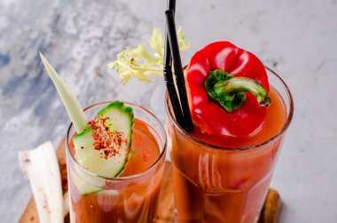 Üstten Görünüm kanlı bir kokteyl olabilir yeşil kereviz, kırmızı pul biber, karabiber ve tuz gri taş tablo arka plan üzerinde ile dekore edilmiştir. Soğuk domates içki. Bar alkol menüsü.