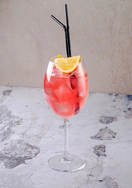 Koktail Aperol Spritz Italia klasik yang terdiri dari air minum, aperitif dan soda dengan potongan jeruk buah segar di kaca anggur di latar belakang. Minuman musim panas merah eksotis. Menu alkohol batang Stok Gambar Bebas Royalti