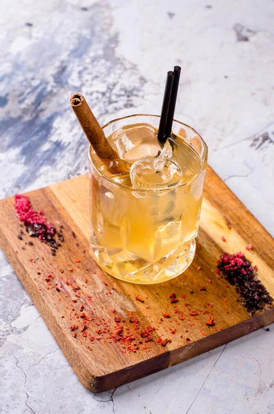 Da vicino, cocktail alcolico marrone con whisky, decorazioni cubetti di ghiaccio su una tavola di legno, sfondo grigio. Menù alcolico bar, bevanda forte per la sera. Spazio per la progettazione del testo, attenzione selettiva . — Foto Stock